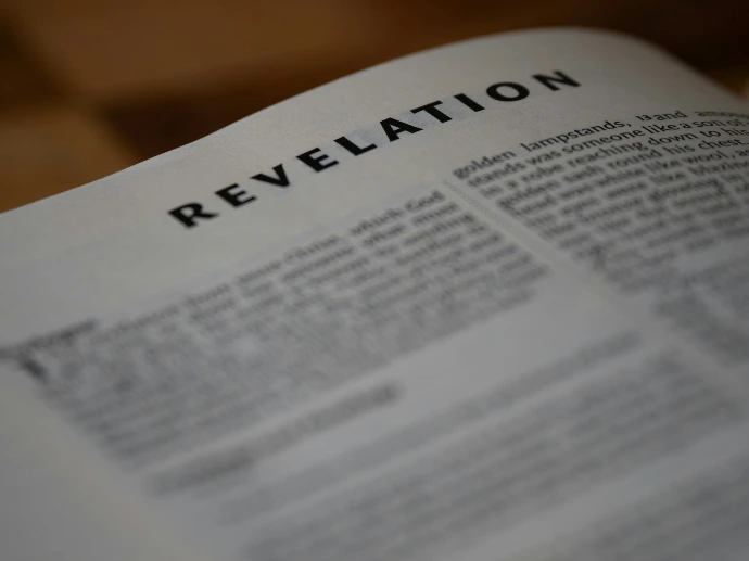The image shows a close-up of the book of revelation.