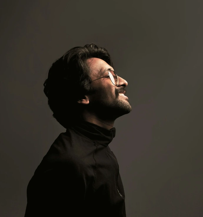 a man with glasses looking up into the sky